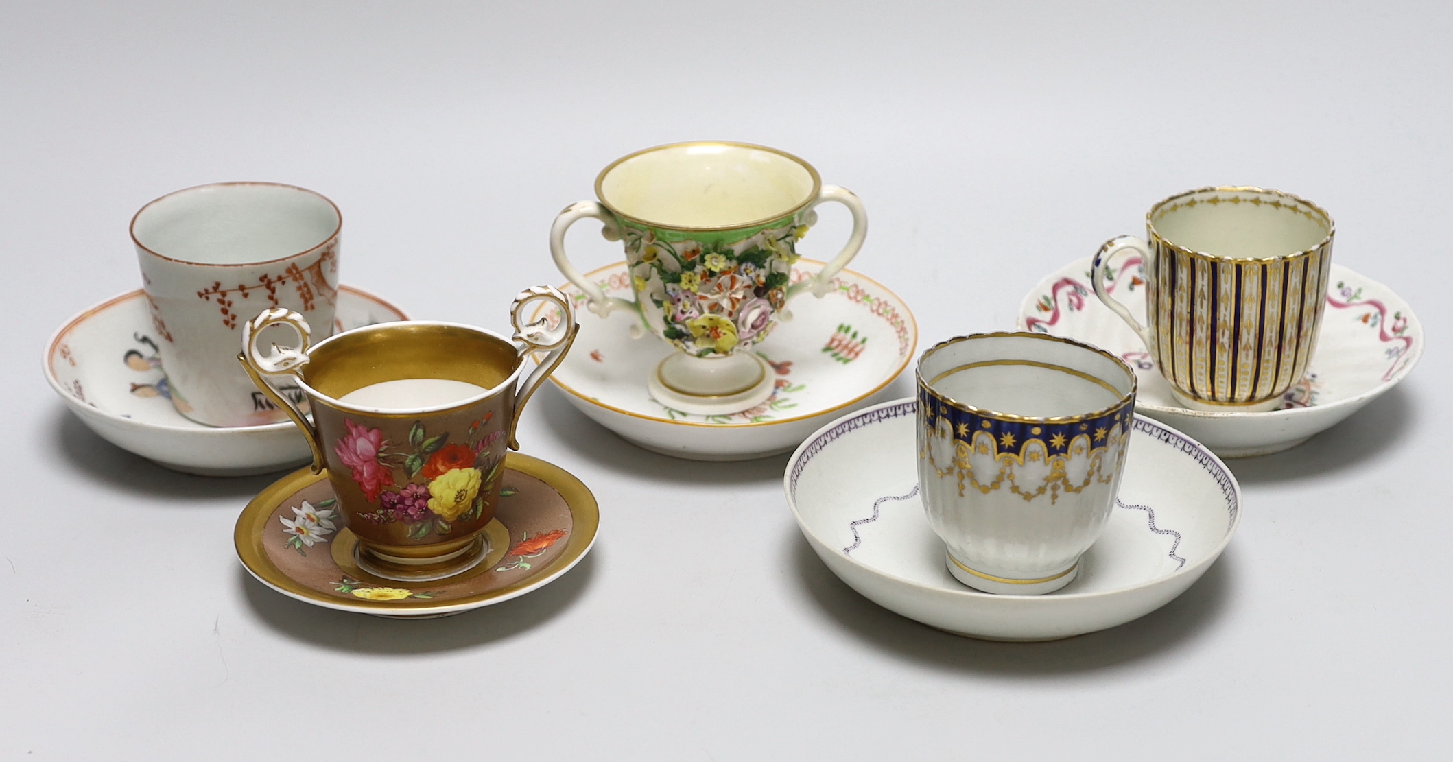 A group of early 19th century English porcelain cups and various saucers to include a Spode two handled chocolate cup and saucer (10)